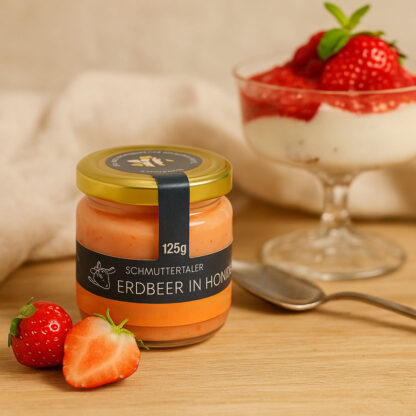 Produktbild: ein Glas Erdbeere in Honig im Hintergrund ein Schälchen Quark mit frischen Erdbeeren